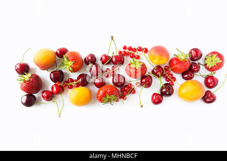 Reife Erdbeeren, Johannisbeeren, Aprikosen und Kirschen auf weißem Hintergrund. Verschiedene frische Sommer Beeren. Ansicht von oben. Beeren am Rand des Bildes mit Cop Stockfoto