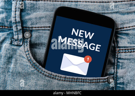 "Neue Nachricht"-Benachrichtigung, Konzept der Bildschirm des Smartphones in Jeans Tasche. Alle Inhalte werden von mir gestaltet. Stockfoto