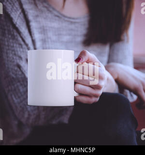 Womans Hände, weiblich, eine weiße leere Kaffeetasse, perfekt für die Darstellung ihres Angebots, Design auf Tassen, die Sie verkaufen. Stockfoto