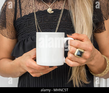 Womans Hände halten eine weiße Tasse, perfekt für die Darstellung ihres Angebots, Design auf Tassen, die Sie verkaufen. Stockfoto