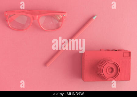 Flach von Brillen, Bleistift und retro Film Foto Kamera. Licht rot gefärbten Hintergrund Konzept. Stockfoto