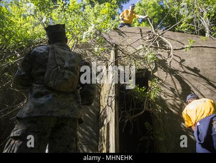 Us-Marines und Matrosen sauber verwilderten Reben und Bürste von der Munition Lagerung Bunker aus dem Zweiten Weltkrieg bei der Marine Woche im Wald Trail, Louisiana, April 23, 2018, 24. April 2018. Während Marine Woche New Orleans, Marinesoldaten und Matrosen sind zur Unterstützung der Gemeinschaften gewidmet. (U.S. Marine Corps Foto von Sgt. Justin T. Updegraff). () Stockfoto