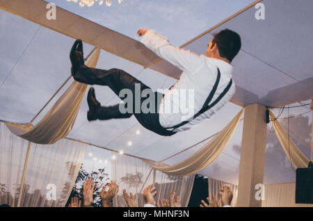 Bräutigam in der luft, lustige Momente einer Hochzeit Stockfoto