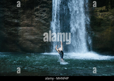 Mann spielt im Wasserfall Velo de La Novia in Chanchamayo - Peru, im Bereich Yurinaki Stockfoto