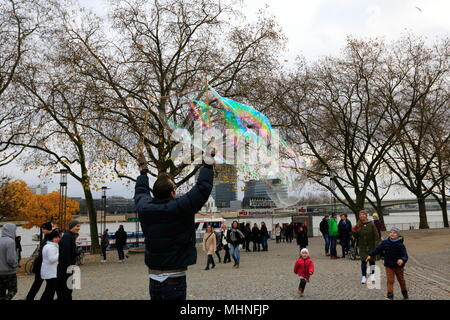 Touristen, Seifenblasen auf der Bank der Rhein bei Köln, Northhine-Westfalia, Deutschland. Stockfoto