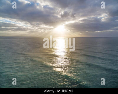 Sonnenuntergang strahlen über ruhige See Wasser Stockfoto