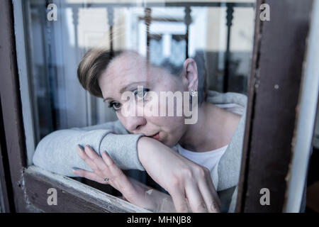 Junge schöne depressiv unglücklich kaukasische Frau besorgt und traurig durch das Fenster zu Hause. Gefühl, wertlos und Schmerzen. closeup. Depressi Stockfoto