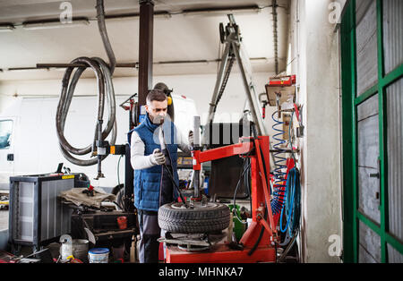 Mann, Mechaniker, Reparatur, ein Auto in eine Garage. Stockfoto