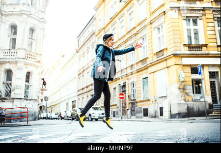 Junge Frau springen auf der Straße in der Stadt. Stockfoto