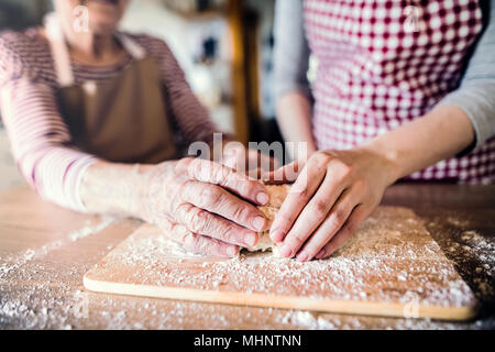 Eine alte Oma mit einem erwachsenen Enkelin zu Hause backen. Stockfoto