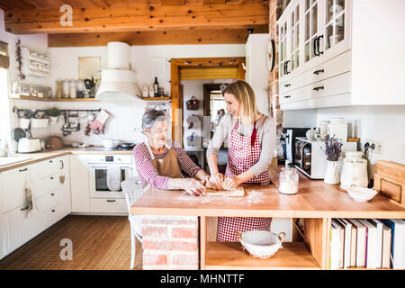 Eine alte Oma mit einem erwachsenen Enkelin zu Hause backen. Stockfoto