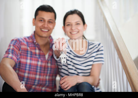 Junges Paar auf Treppen Holding Schlüssel zu neuen Zuhause sitzen Stockfoto