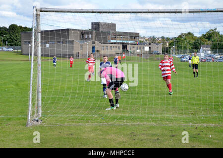 GLASGOW, Schottland - 24. AUGUST 2014: Ein Fußball geht zwischen den Beinen des Torhüters. Stockfoto