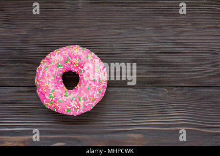 Eine einzelne Donut auf braunem Holz- Hintergrund Stockfoto