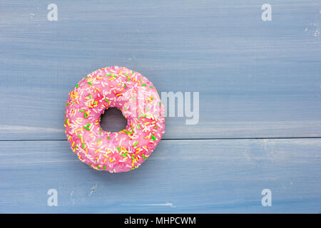 Eine einzelne Donut auf Blau Holz- Hintergrund Stockfoto