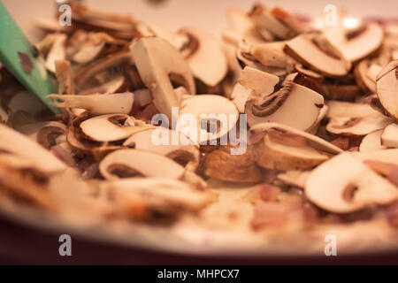 In Scheiben geschnittenen Champignons und gehackte rote Zwiebel in der Pfanne. Stockfoto