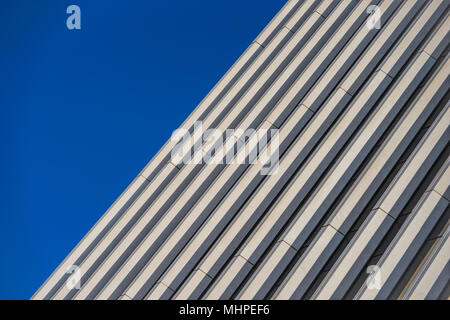 Parallele Linien für die Seite von einem Hochhaus unter einem tiefblauen Himmel. Stockfoto