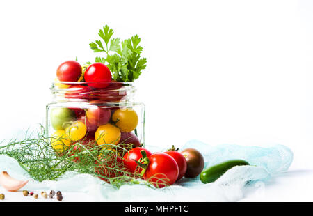 Rote und gelbe Kirschtomaten in einem Glas isoliert auf weißem Stockfoto