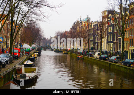 AMSTERDAM, NIEDERLANDE, April, 23 2018: Blick auf einige Autos auf der Straße in der Kanäle von Amsterdam geparkt in der Nähe viele Boote, ist die Hauptstadt und die bevölkerungsreichste Stadt der Niederlande Stockfoto