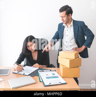 Weibliche Büroangestellte arbeitet unter dem Druck von Supervisor Stockfoto