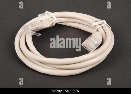 Patchkabel grau Netzwerkkabel mit RJ45-Stecker, auf einem schwarzen Hintergrund isoliert Stockfoto