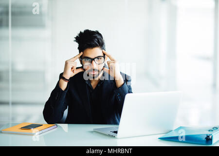 Closeup Portrait eines langen Kerl tief in Gedanken, während Sie an seinem Laptop, Studium ernst, auf eine Stadt und Natur Hintergrund in seinem Haus isoliert oder Stockfoto