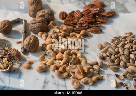 Sammlung von Muttern auf Marmor mit Mutter Cracker Stockfoto