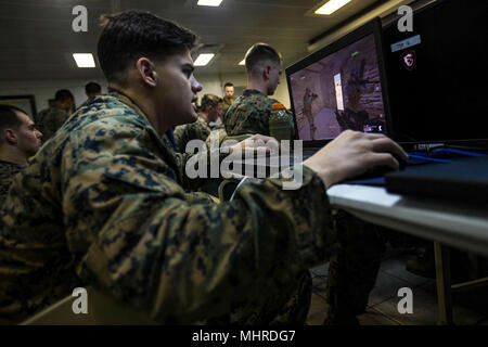 Mittelmeer (3. März 2018) US Marine Cpl. Jakob M. Novitski, ein rifleman zugeordnet Bataillon Landung Team, 2.BATAILLON, 6 Marine Regiment (BLT 2/6), 26 Marine Expeditionary Unit (MEU), kommuniziert seine Position zu Marines während der Teilnahme an simulierten Squad-level Integriertes Training mit Virtual Battlespace Simulator III (VBS-III), ein computer-generierten Combat Training Programm, an Bord der Wasp-Klasse amphibisches Schiff USS Iwo Jima (LHD7), 3. März 2018. Iwo Jima und der 26 MEU leiten naval Operations in den USA 6 Flotte Bereich der Operationen. (U.S. Marine Corps Stockfoto