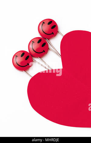 Kunststoff Kopf metall Sicherheitsnadeln in Herzform Papier festgesteckt. Rot Lächeln emoticon Safety Pin. Nett und lustig bunte Emoticons. Stockfoto