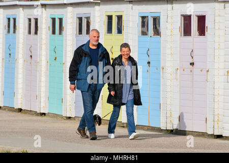 Lyme Regis, Dorset, Großbritannien. 3. Mai 2018. UK Wetter. Ein Paar mit einem Hund zu Fuß entlang der Strandpromenade an einem Morgen von warmen Sonnenschein in den Badeort Lyme Regis in Dorset. Foto: Graham Jagd-/Alamy leben Nachrichten Stockfoto
