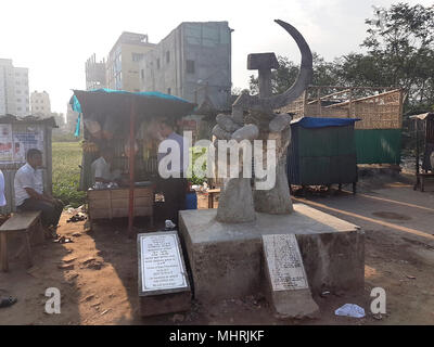 10 April 2018, Bangladesch Savar: ein Hammer und Sicle Statue steht neben einer Gedenktafel, die lautet: "Unsere Erinnerungen mit Milliarden von Tränen' ausgebaggert werden an dem Ort, an dem die ehemalige Rana Plaza Fabrikgebäude verwendet werden. Fünfer Jahre nach dem Zusammenbruch der Rana Plaza Gebäude, das mehr als 1.100 Toten, die Situation in Bangladeschs Textilindustrie hat leichte trotz anhaltender Probleme verbessert. Foto: Nick Kaiser/dpa Stockfoto