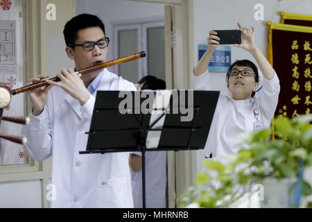 (180503) - Peking, Mai 3, 2018 (Xinhua) - Eine Krankenschwester macht ein Video von medical student Chen Wei, ein Mitglied der 'Xieyun' Orchestra, spielt Flöte in einem Bezirk von Peking Union Medical College Hospital (PUMCH) in Peking, der Hauptstadt von China, 23. April 2018. 2015, PUMCH Ärzte und Peking Union Medical College Studenten gestartet Die "Xieyun' Orchester. Jeden Monat, Mitglieder von 'Xieyun' würde freiwillig ein oder zwei musikalische Darbietungen für Patienten, ihre Familien und andere medizinische Arbeiter. Das Orchester wurde weitgehend von seinem Publikum für seine Leistungen und Anliegen der Mitglieder und die l geschätzt Stockfoto