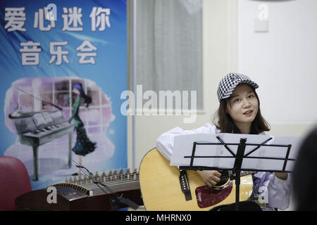 (180503) - Peking, Mai 3, 2018 (Xinhua) - Student der Medizin Xiang Yirong, Mitglied der "Xieyun' Orchestra, spielt Gitarre in einer Gemeinde von Peking Union Medical College Hospital (PUMCH) in Peking, der Hauptstadt von China, 23. April 2018. 2015, PUMCH Ärzte und Peking Union Medical College Studenten gestartet Die "Xieyun' Orchester. Jeden Monat, Mitglieder von 'Xieyun' würde freiwillig ein oder zwei musikalische Darbietungen für Patienten, ihre Familien und andere medizinische Arbeiter. Das Orchester wurde weitgehend von seinem Publikum für seine Leistungen und Anliegen der Mitglieder und die Liebe zu den Patienten geschätzt. Stockfoto