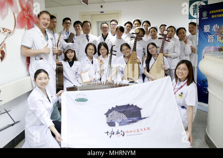 (180503) - Peking, 3. Mai 2018 (Xinhua) - Mitglieder des 'Xieyun' Orchester für ein Gruppenfoto posieren Nach einer Leistung in einem Bezirk von Peking Union Medical College Hospital (PUMCH) in Peking, der Hauptstadt von China, 23. April 2018. 2015, PUMCH Ärzte und Peking Union Medical College Studenten gestartet Die "Xieyun' Orchester. Jeden Monat, Mitglieder von 'Xieyun' würde freiwillig ein oder zwei musikalische Darbietungen für Patienten, ihre Familien und andere medizinische Arbeiter. Das Orchester wurde weitgehend von seinem Publikum für seine Leistungen und Anliegen der Mitglieder und die Liebe zu den Patienten geschätzt. ( Stockfoto