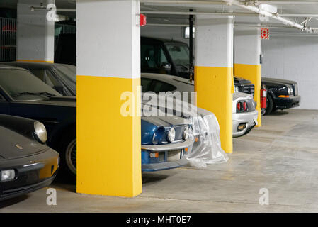 Teurer Luxus Autos in einer Tiefgarage in Montreal, Quebec. Sie sind im Staub bedeckt, wie sie seit Jahren nicht benutzt worden sind. Stockfoto