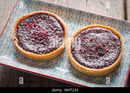 Himbeere und Schokolade Fondant tart. Alle butter Gebäck Torte mit Schokolade befüllen und Himbeer Kompott Zentrum, beendete mit Himbeere & Schokolade Stockfoto