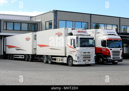 Volvo FH und Scania gekühlten Anhänger Lkw abladen auf warehause loading Zone, die auf einem klaren Sommernachmittag in Salo, Finnland - 21. Juli 2017. Stockfoto