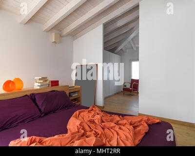 Interieur Schüsse eines modernen Schlafzimmer im Dachgeschoss Zimmer im Vordergrund das Bett aus Holz der Boden aus Holz ist Stockfoto