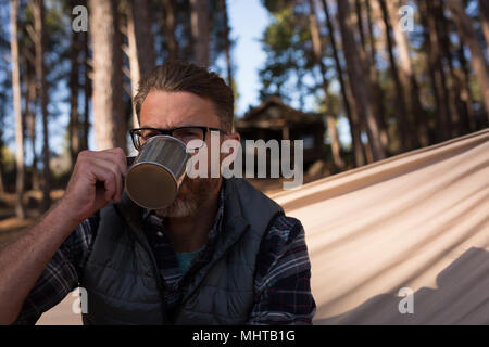 Man Kaffee trinken und entspannen Sie auf der Hängematte Stockfoto