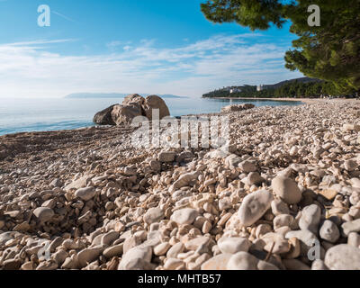 Kiesstrand und ruhige blaue Meer Horizont in Tucepi, Kroatien Stockfoto