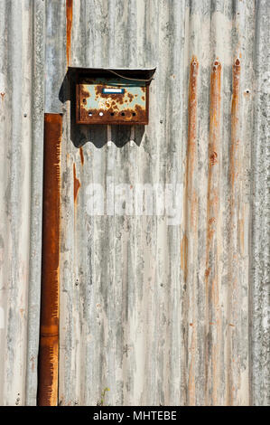 Alten rostigen Briefkasten auf einer metallenen gewellte Zaun Stockfoto