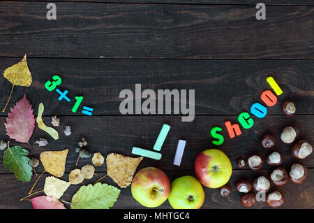 Schule Thema. Herbst Blätter, Kastanien und reife Äpfel auf einem dunklen Hintergrund. An Bord der Platz für Ihr Objekt (die Inschrift). Stockfoto