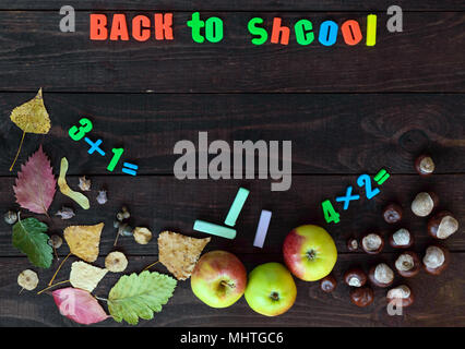 Schule Thema. Herbst Blätter, Kastanien und reife Äpfel auf einem dunklen Hintergrund. An Bord der Platz für Ihr Objekt (die Inschrift). Stockfoto