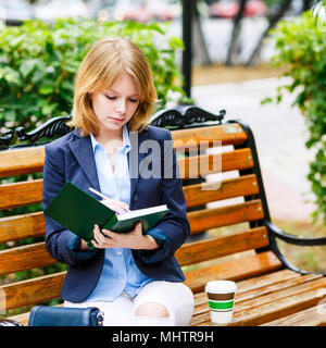 Junge Frau Studium und Schreiben in einem Park. Stockfoto