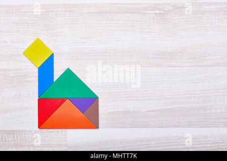 Ein Haus mit einem Rohr aus farbigem Puzzleteile zusammengesetzt. Auf der rechten Seite ist Platz für Text Stockfoto