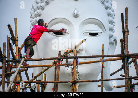 Kanchanaburi, Thailand - 15. September 2011: Arbeiter renovieren riesige weiße Buddha Bild auf Bambus Gerüst in buddhistischen Tempel in Kanchanaburi, Thail Stockfoto