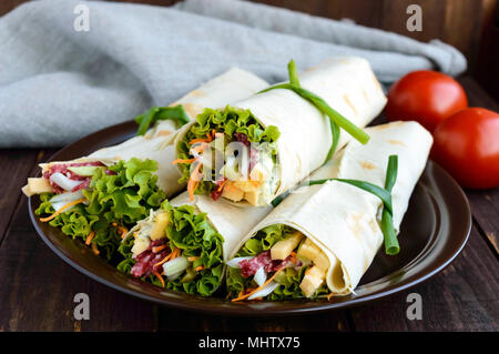 Vorspeise von Pita (LAVASH) gefüllt mit: Salami, Käse, Gurken, Karotten, Soße, Grüns. Shawarma Stockfoto