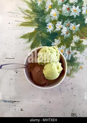 Auswahl an Gourmet Aromen der italienischen Eis in lebendigen Farben in einzelnen Kunststoffboxen auf einem alten rustikalen Holztisch serviert in einem Eis p Stockfoto