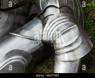 Poliertes Metall schützende Rüstung eines mittelalterlichen Ritter legt auf dem grünen Rasen Stockfoto