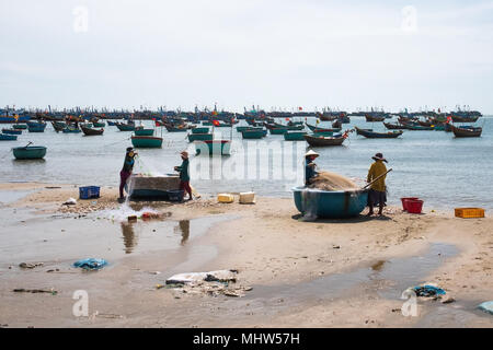 Muine, Vietnam - 27. November 2017: Fischer Reinigung Netze aus Fisch auf Muine Strand während des Tages Stockfoto